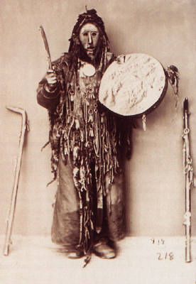 shaman in ritual costume with tambourine